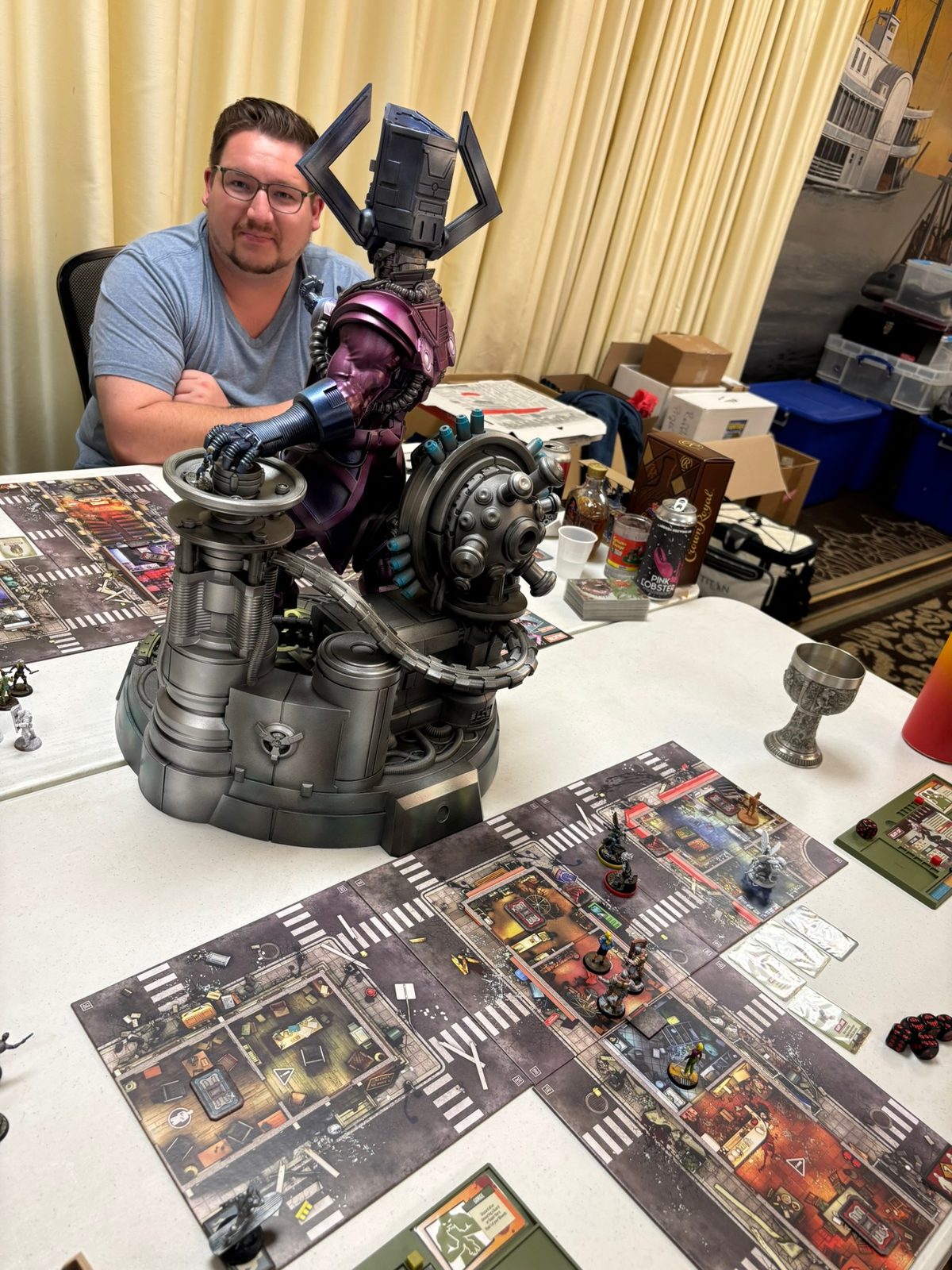 Players gaming with a large mecha miniature centerpiece