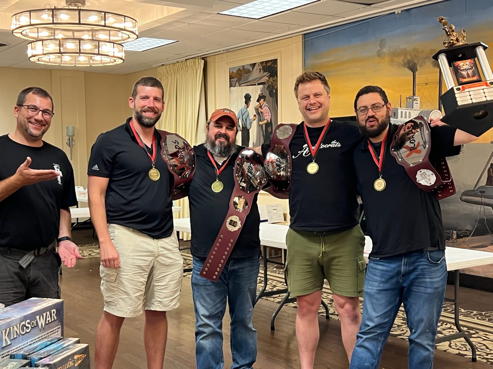 Champions posing with their Kings of War championship belts